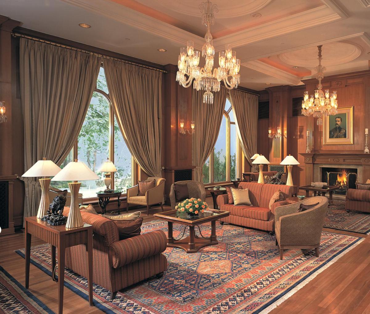 a living room with furniture and a chandelier at Wildflower Hall, An Oberoi Resort, Shimla in Shimla