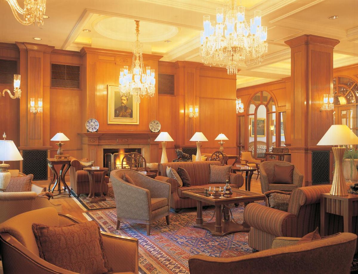 a hotel lobby with chairs and a fireplace at Wildflower Hall, An Oberoi Resort, Shimla in Shimla