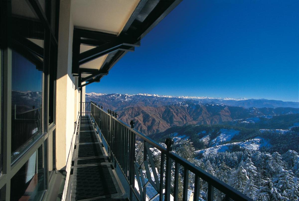 a balcony of a building with a view of the mountains at Wildflower Hall, An Oberoi Resort, Shimla in Shimla