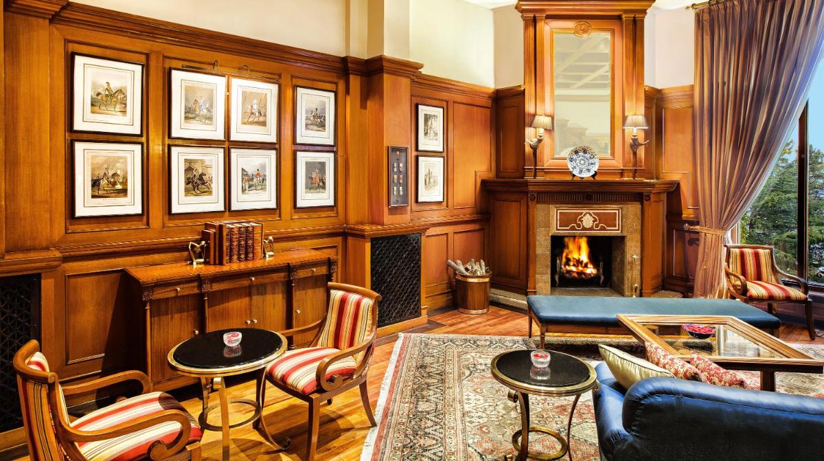 a living room with a fireplace and a couch at Wildflower Hall, An Oberoi Resort, Shimla in Shimla
