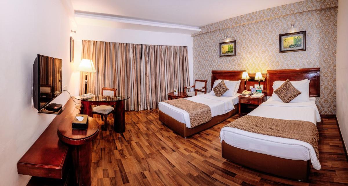 a hotel room with two beds and a television at Fortune JP Palace, Mysore - Member ITC Hotels' Group in Mysore
