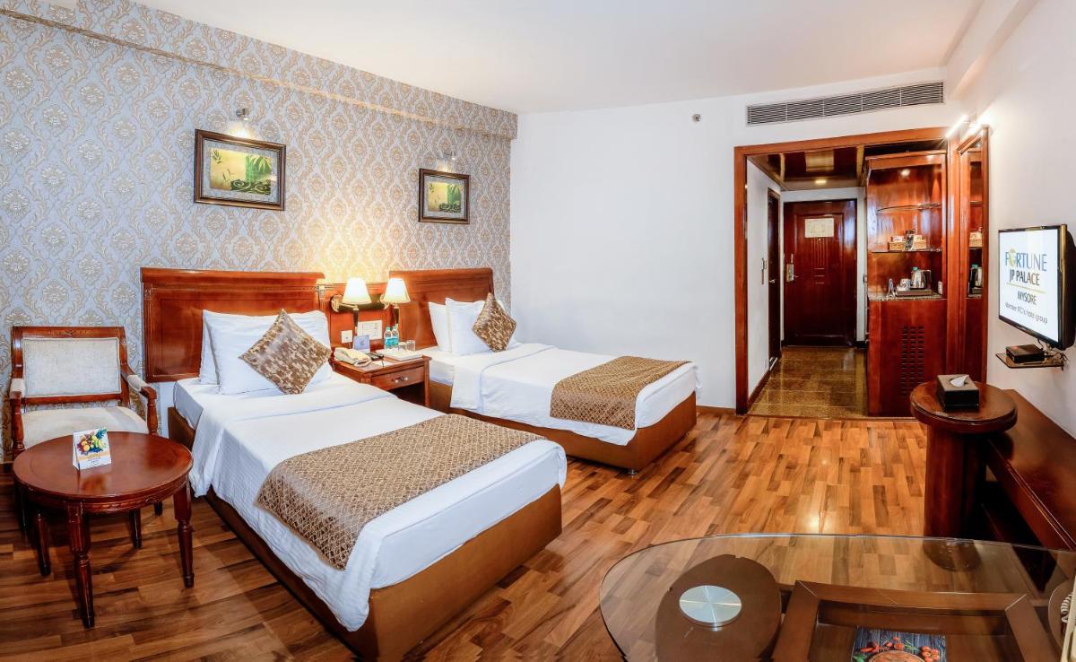 a hotel room with two beds and a table at Fortune JP Palace, Mysore - Member ITC Hotels' Group in Mysore
