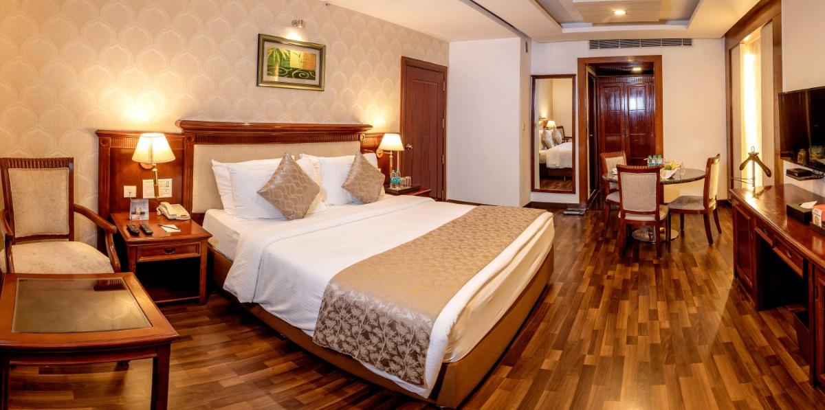 a bedroom with a bed and a table and a chair at Fortune JP Palace, Mysore - Member ITC Hotels' Group in Mysore