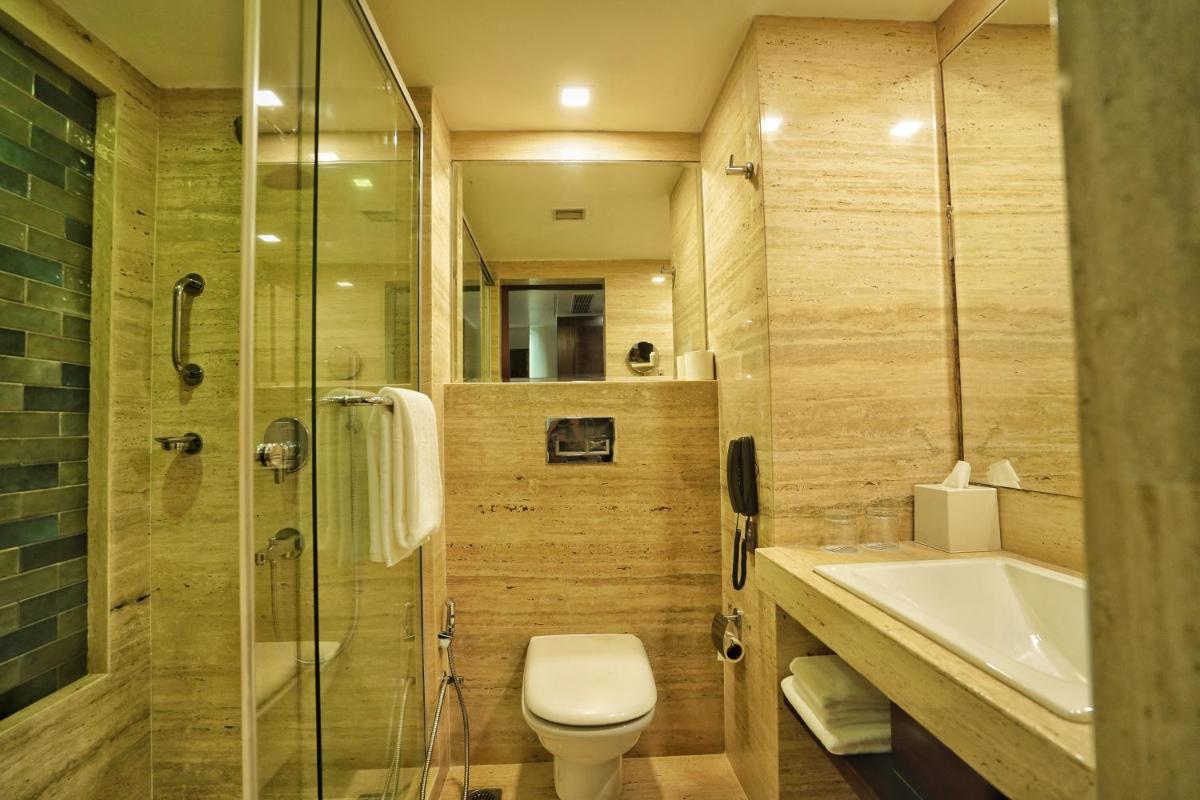 a bathroom with a toilet and a sink and a shower at Hyatt Centric Rajpur Road Dehradun in Dehradun