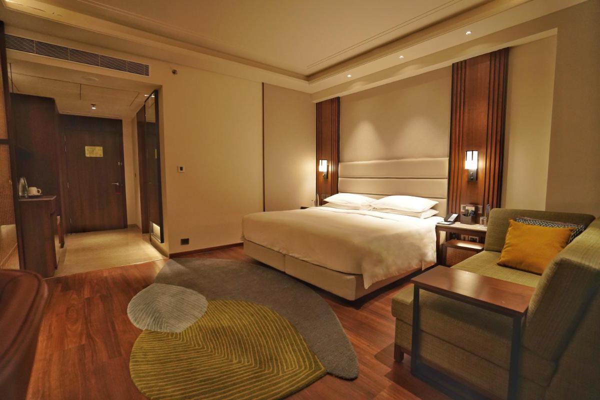a hotel room with a bed and a couch at Hyatt Centric Rajpur Road Dehradun in Dehradun