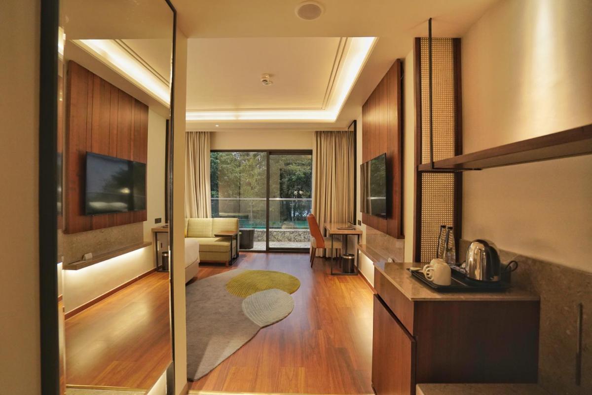 a living room with a television and a living room at Hyatt Centric Rajpur Road Dehradun in Dehradun