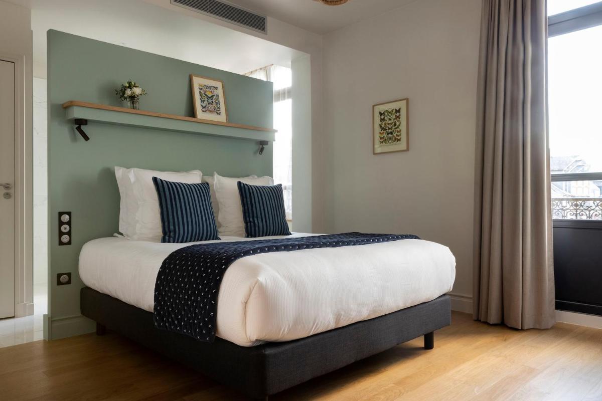 Un ou plusieurs lits dans un hébergement de l'établissement L'INVITATION AU VOYAGE - Hôtel & Spa