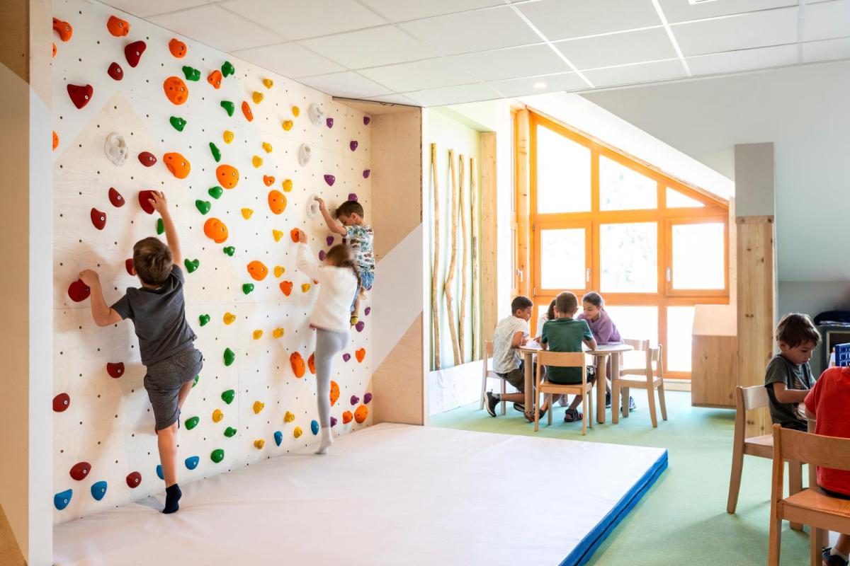 un groupe d'enfants jouant sur un mur d'escalade dans l'établissement Résidence Club MMV Le Silvana, à Risoul