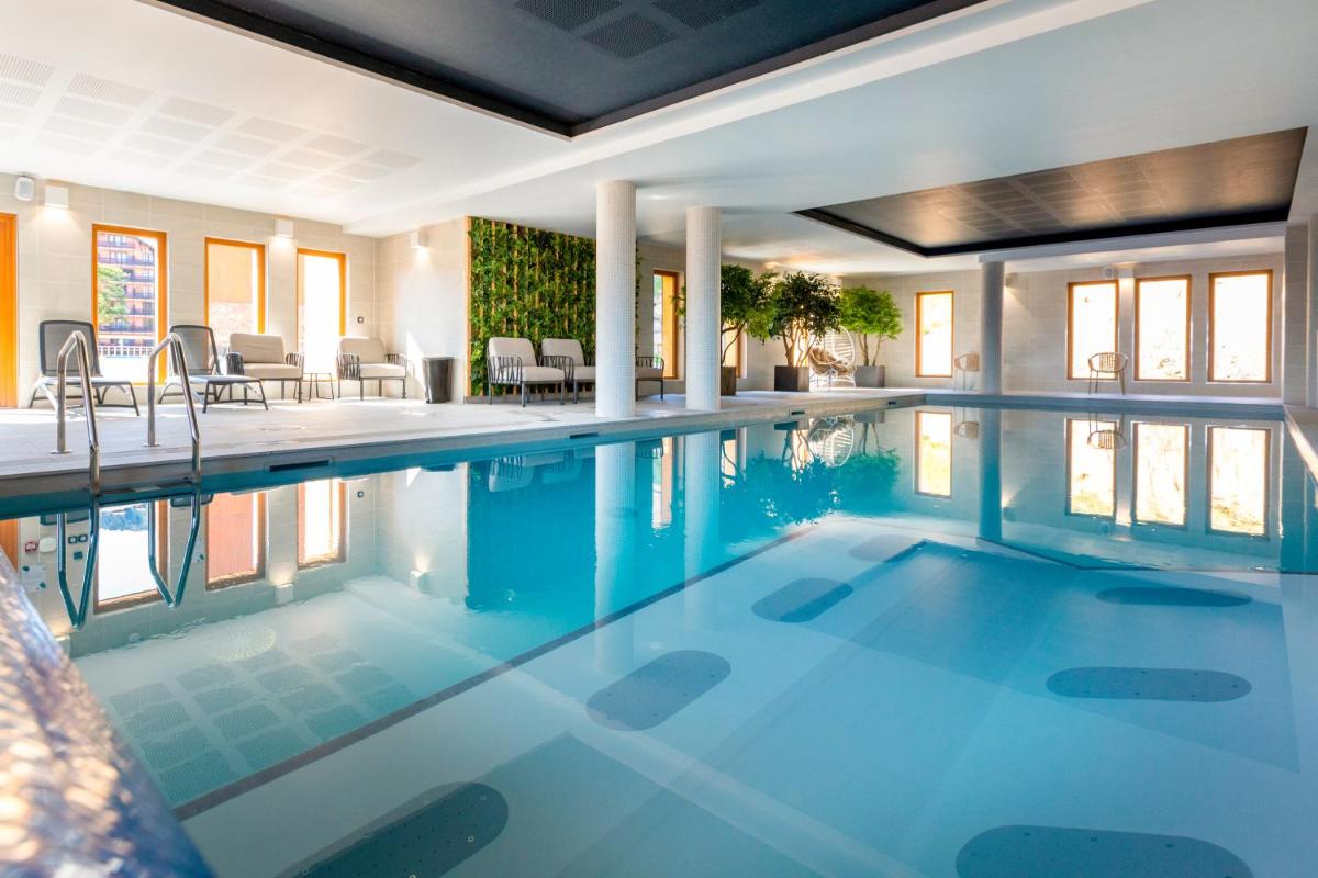 une piscine avec de l'eau bleue dans une maison dans l'établissement Résidence Club MMV Le Silvana, à Risoul