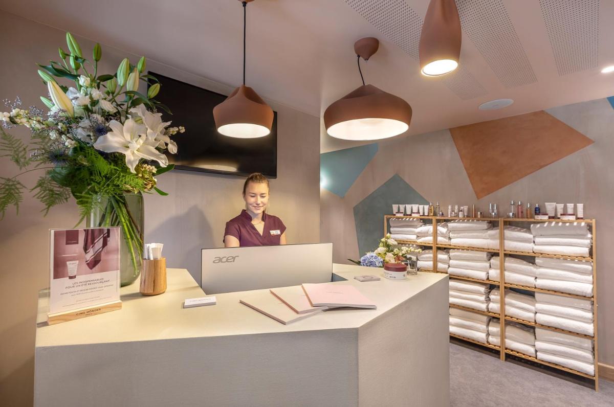 une femme assise à un bureau avec un ordinateur portable dans l'établissement Chalet Hôtel Le Prieuré & Spa, à Chamonix-Mont-Blanc 69 autres photos