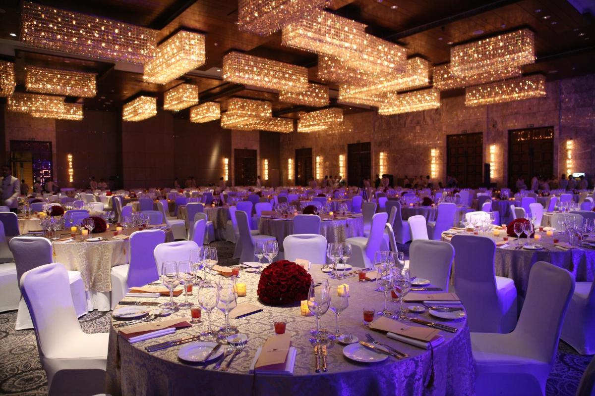 a banquet hall with white tables and chairs and lights at JW Marriott Hotel New Delhi Aerocity in New Delhi a banquet hall with white tables and chairs and lights at JW Marriott Hotel New Delhi Aerocity in New Delhi