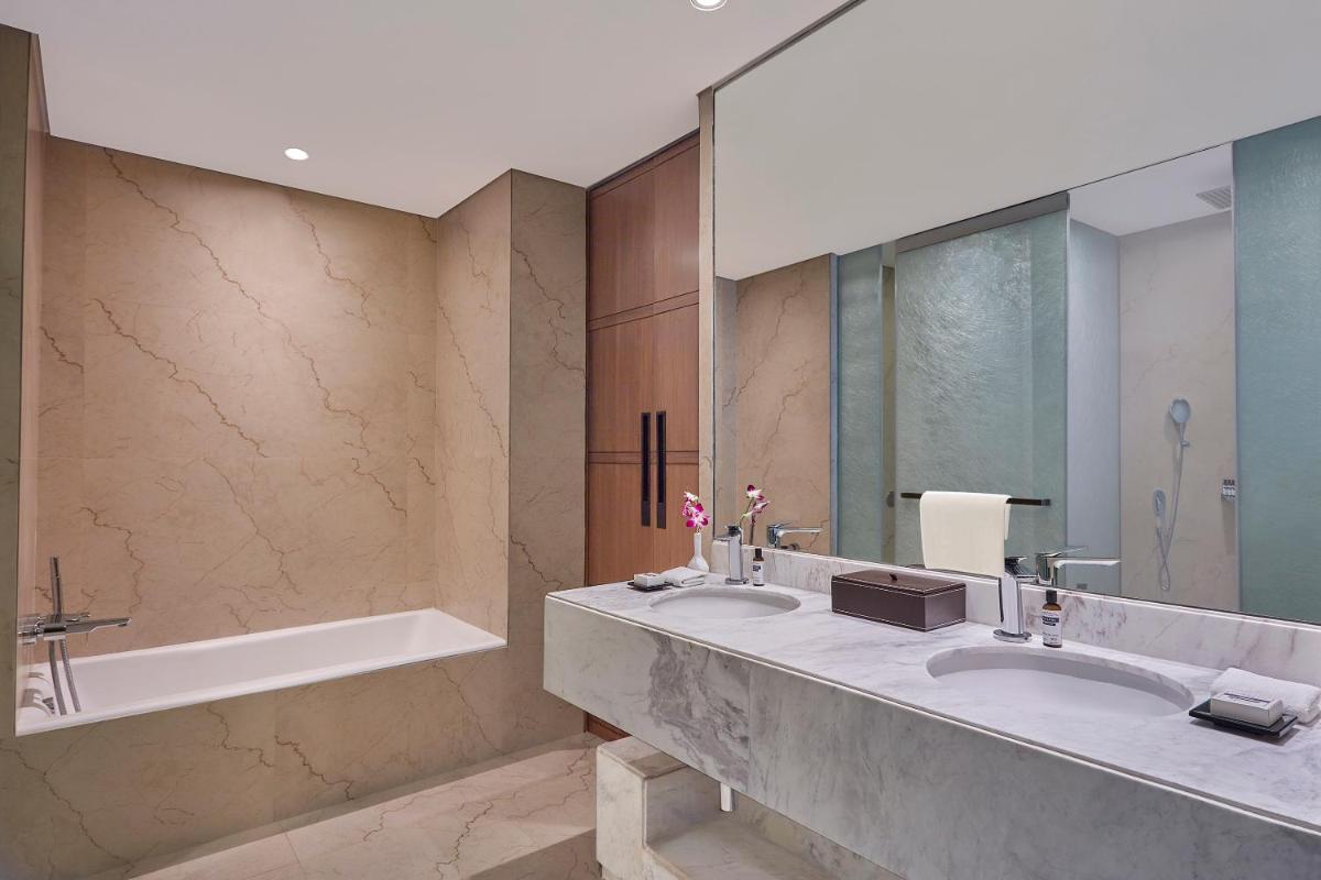 a bathroom with two sinks and a bath tub at Hyatt Regency Chennai in Chennai