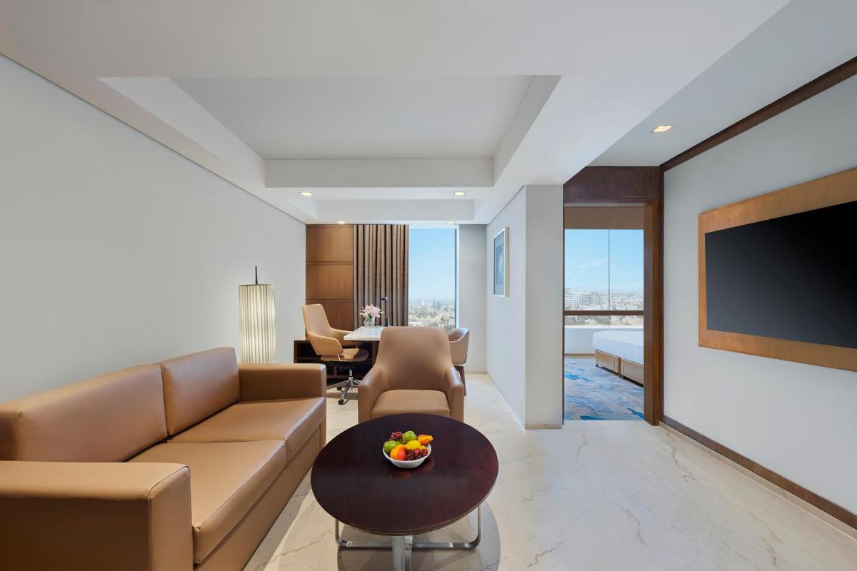 a living room with a couch and a flat screen tv at Hyatt Regency Chennai in Chennai