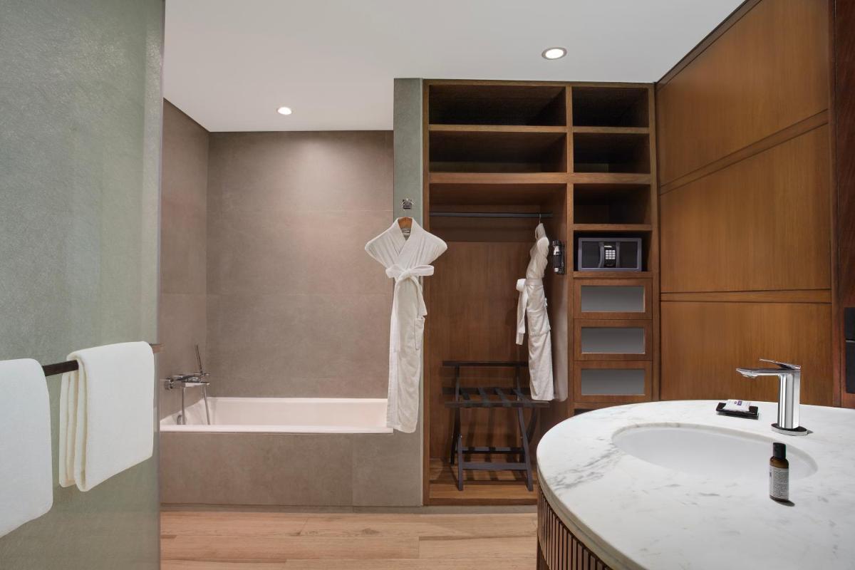 a bathroom with a bath tub and a sink and a bath tub at Hyatt Regency Chennai in Chennai