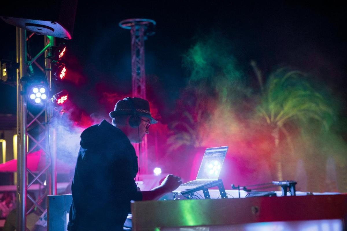 um homem em pé na frente de um laptop em um palco em ROBINSON QUINTA DA RIA - All Inclusive em Vila Nova de Cacela mais 94 fotografias