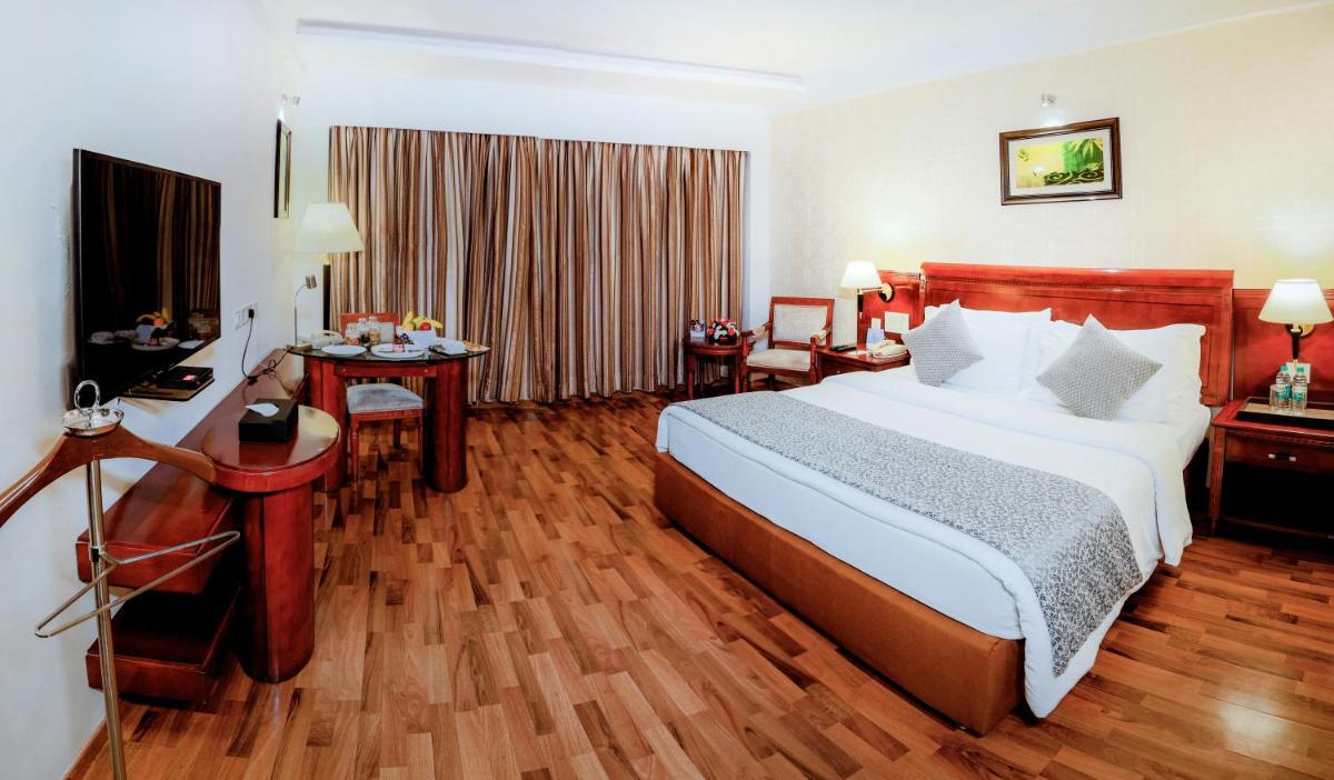 a hotel room with a large bed and a desk at Fortune JP Palace, Mysore - Member ITC Hotels' Group in Mysore