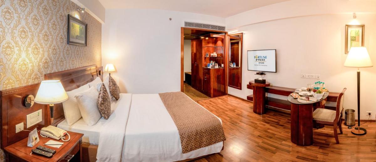 a hotel room with a bed and a table and a chair at Fortune JP Palace, Mysore - Member ITC Hotels' Group in Mysore