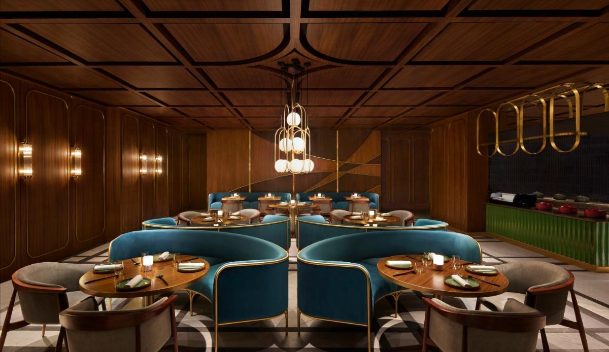 a dining room with blue chairs and tables at Taj The Trees, Mumbai in Mumbai