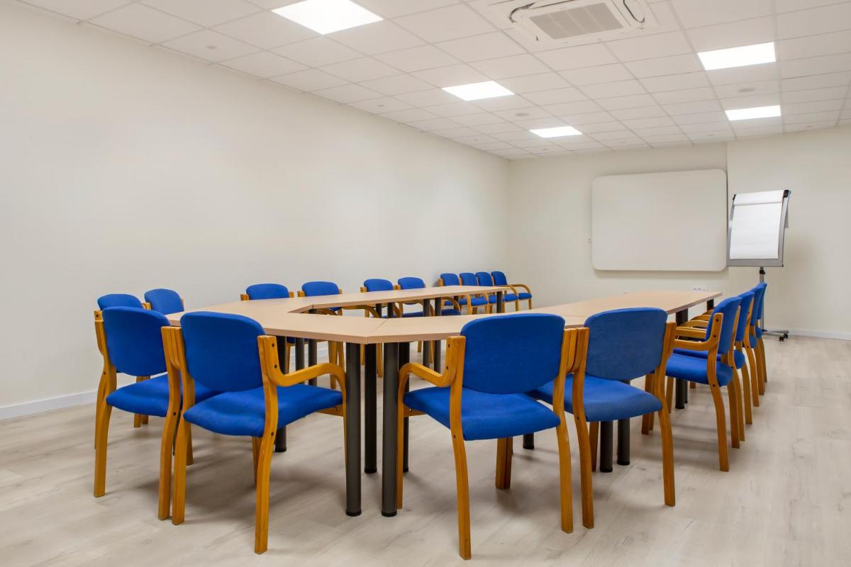 Una sala de conferencias con una mesa larga y sillas azules. en Royal Oasis Club at Pueblo Quinta, en Benalmádena 29 fotos más