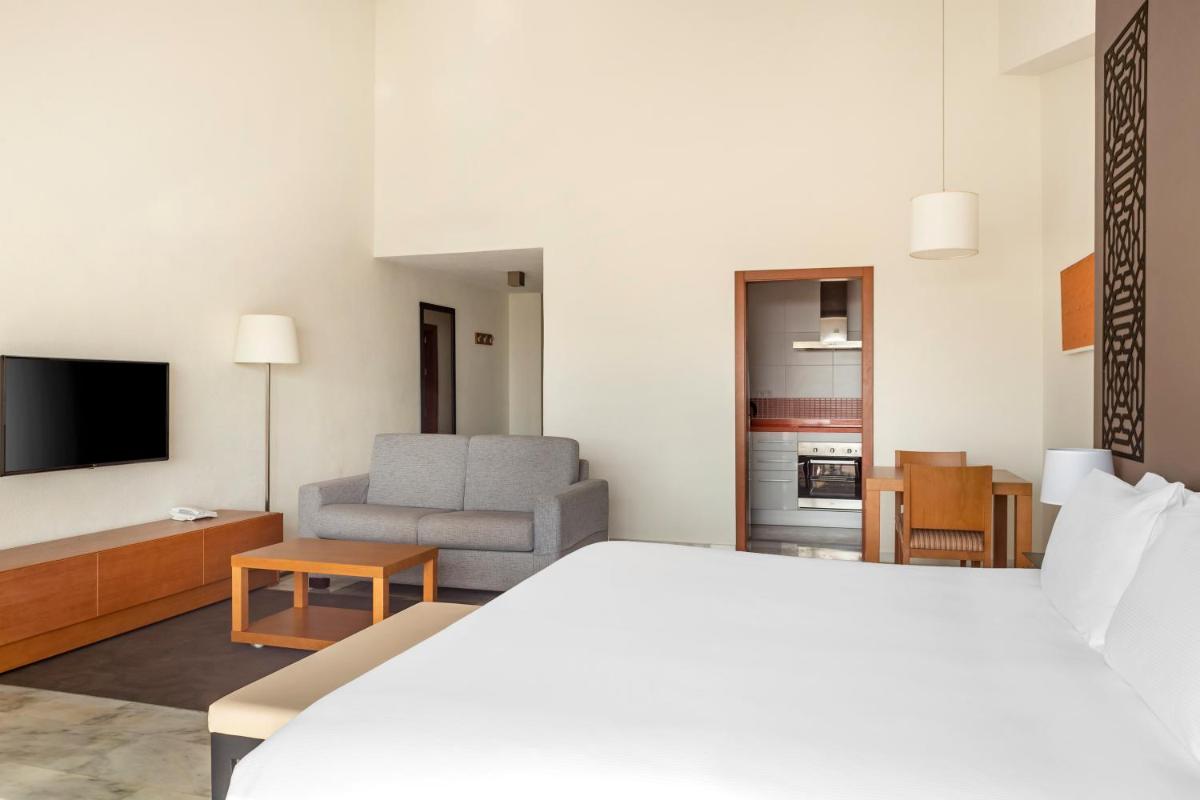 Una habitación de hotel con una cama y una sala de estar. en Sahara Sunset, en Benalmádena 35 fotos más