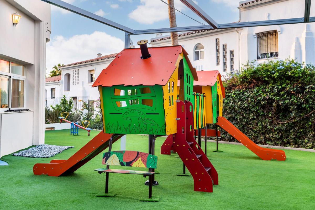 Un parque infantil con un tobogán en un patio en Sahara Sunset, en Benalmádena