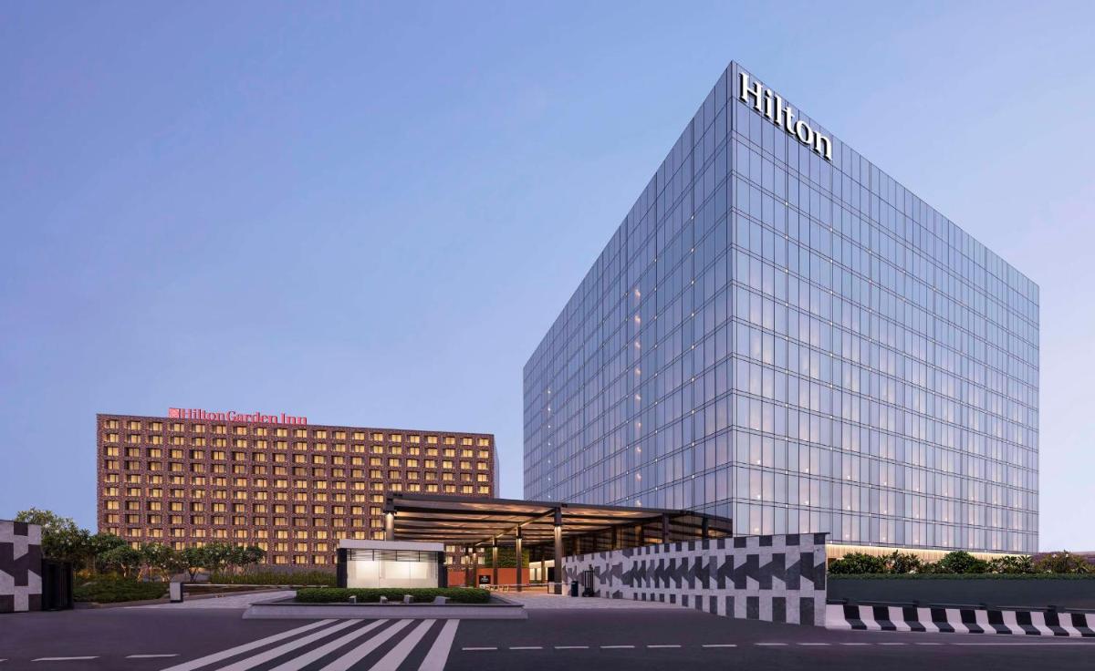 a tall building with a sign on top of it at Hilton Bengaluru Embassy Manyata Business Park in Bengaluru +85 photos