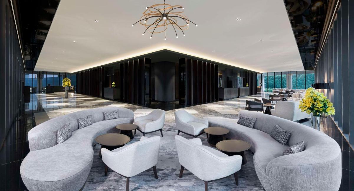 a lobby with couches and tables and a chandelier at Hilton Bengaluru Embassy Manyata Business Park in Bengaluru