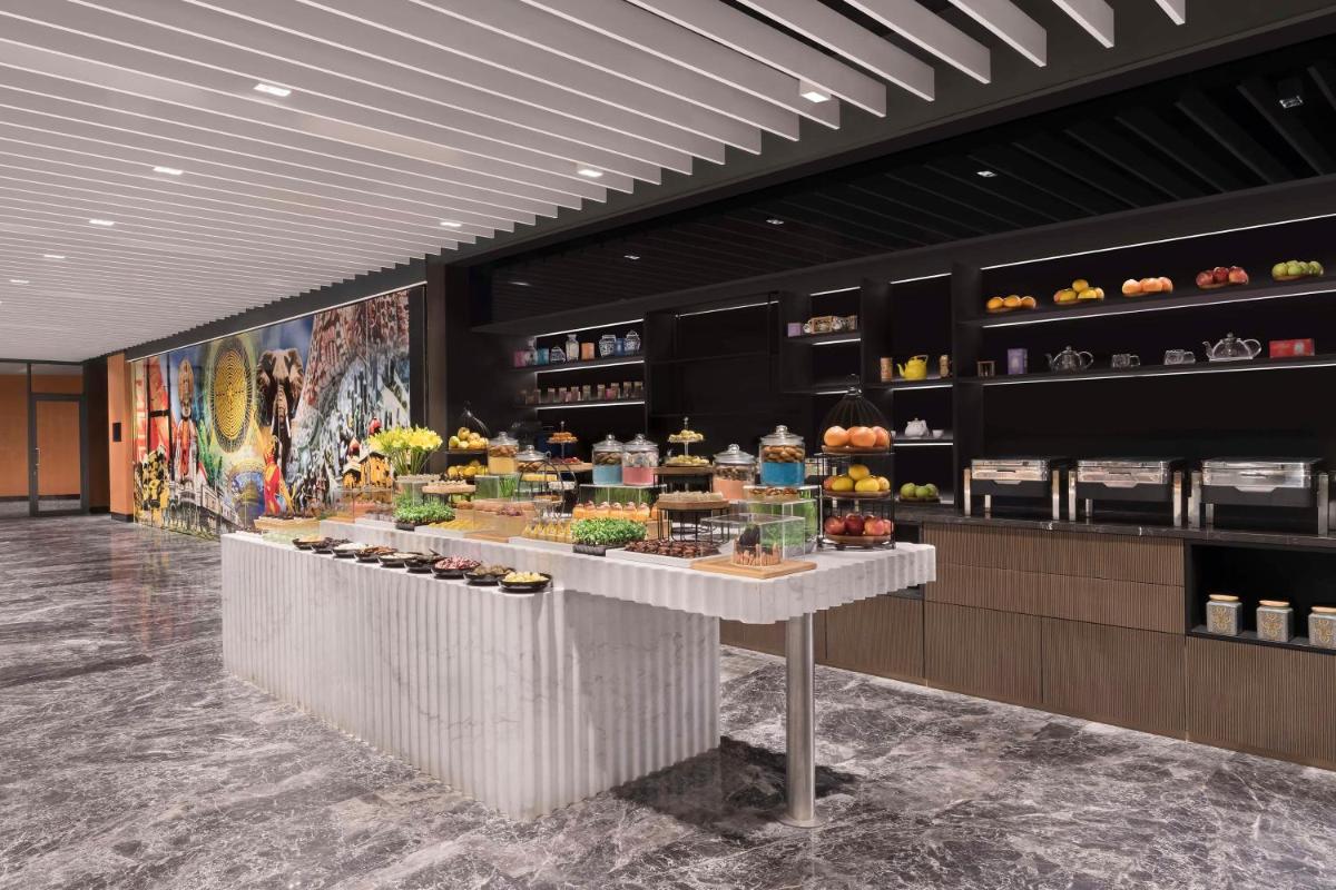 a bakery with a display of food on a counter at Hilton Bengaluru Embassy Manyata Business Park in Bengaluru