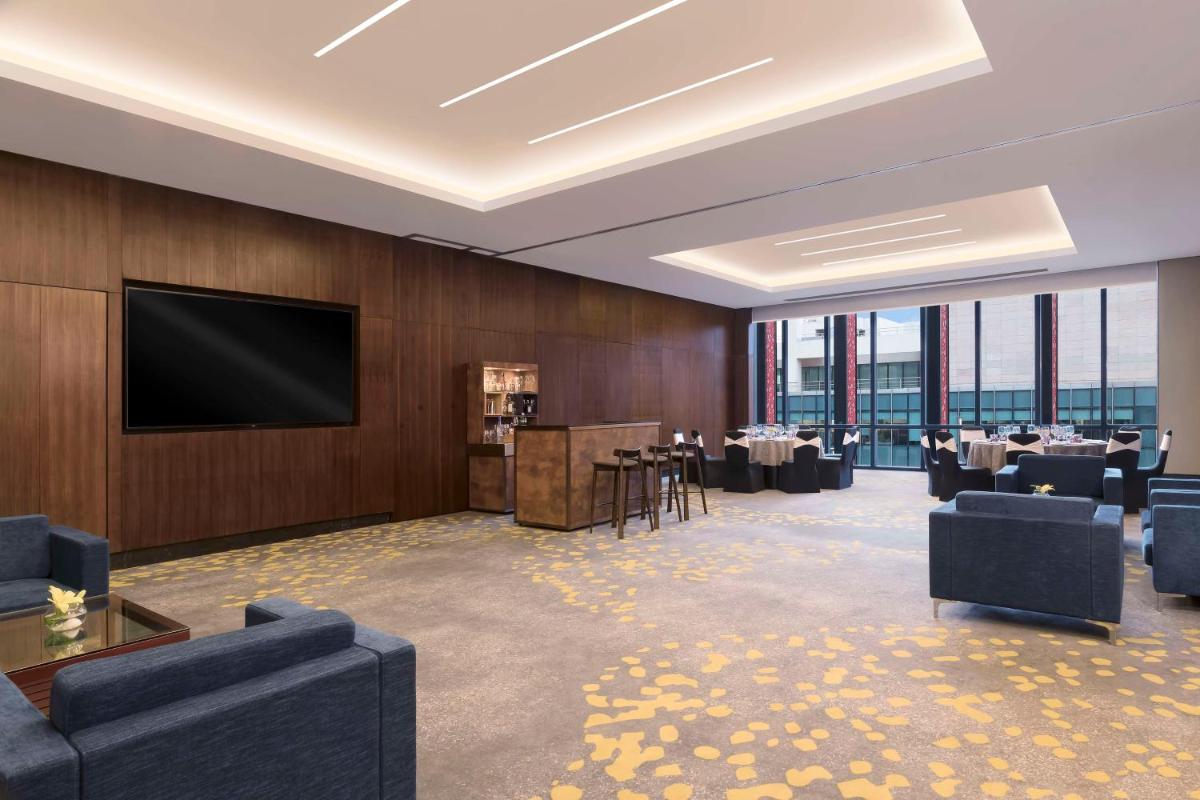 a dining room with tables and a flat screen tv at Hilton Bengaluru Embassy Manyata Business Park in Bengaluru