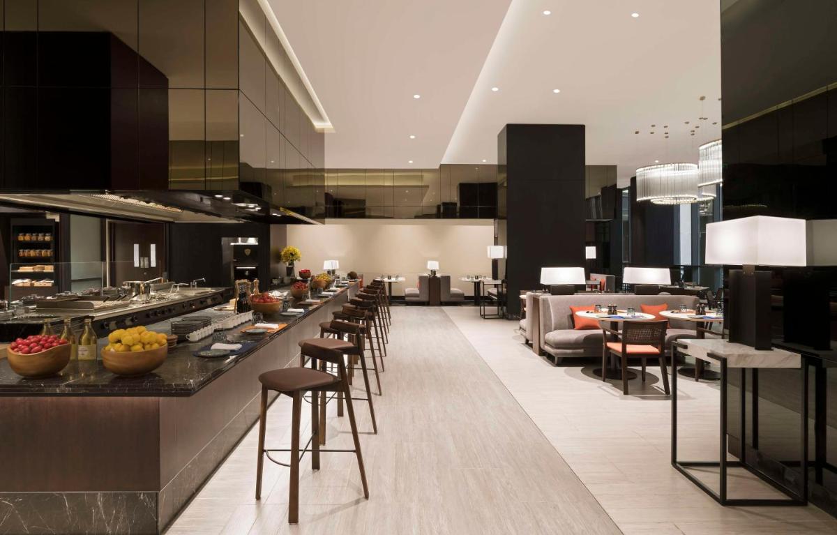 a lobby with a bar with chairs and a couch at Hilton Bengaluru Embassy Manyata Business Park in Bengaluru