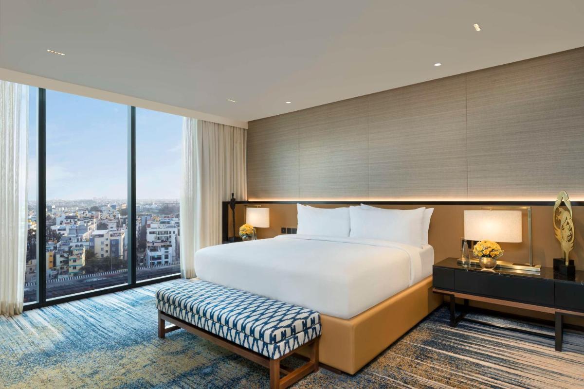 a hotel room with a bed and a large window at Hilton Bengaluru Embassy Manyata Business Park in Bengaluru