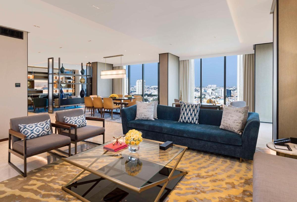 a living room with a blue couch and chairs at Hilton Bengaluru Embassy Manyata Business Park in Bengaluru