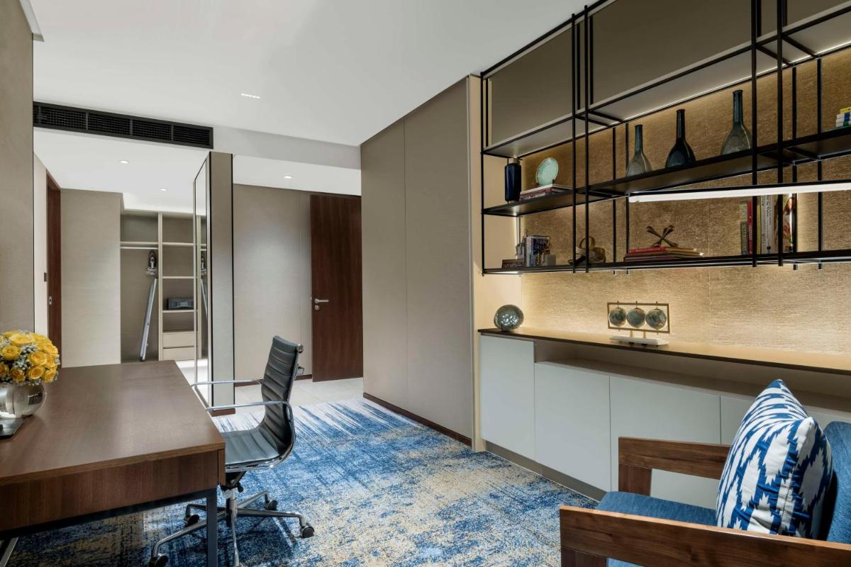 an office with a desk and a table and chairs at Hilton Bengaluru Embassy Manyata Business Park in Bengaluru