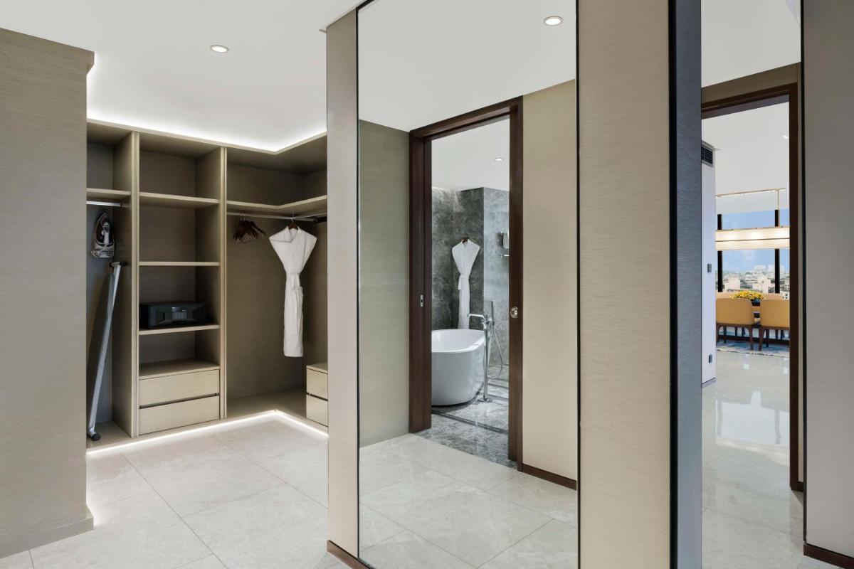 a bathroom with sliding glass doors and a toilet at Hilton Bengaluru Embassy Manyata Business Park in Bengaluru