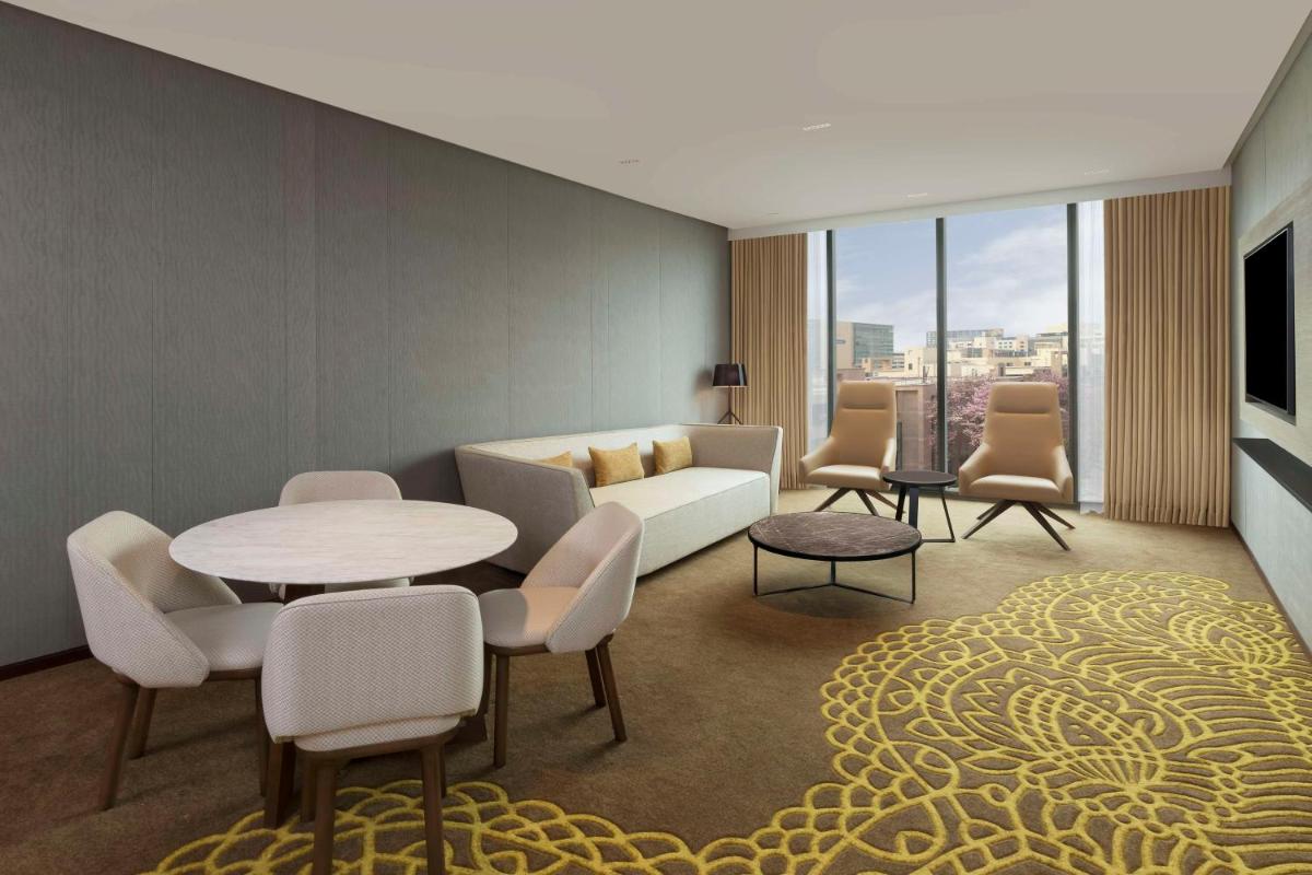 a living room with a couch and a table and chairs at Hilton Bengaluru Embassy Manyata Business Park in Bengaluru