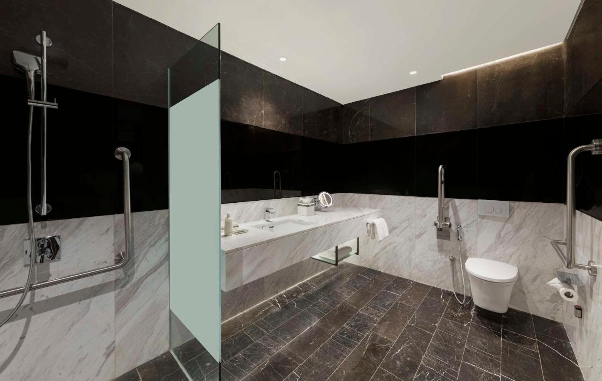 a bathroom with two sinks and a toilet in a room at Hilton Bengaluru Embassy Manyata Business Park in Bengaluru