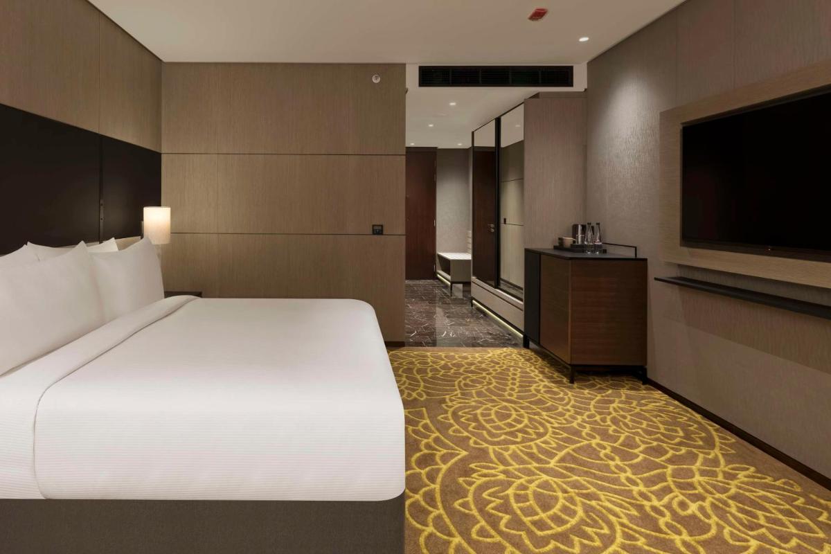 a bedroom with a large bed and a flat screen tv at Hilton Bengaluru Embassy Manyata Business Park in Bengaluru