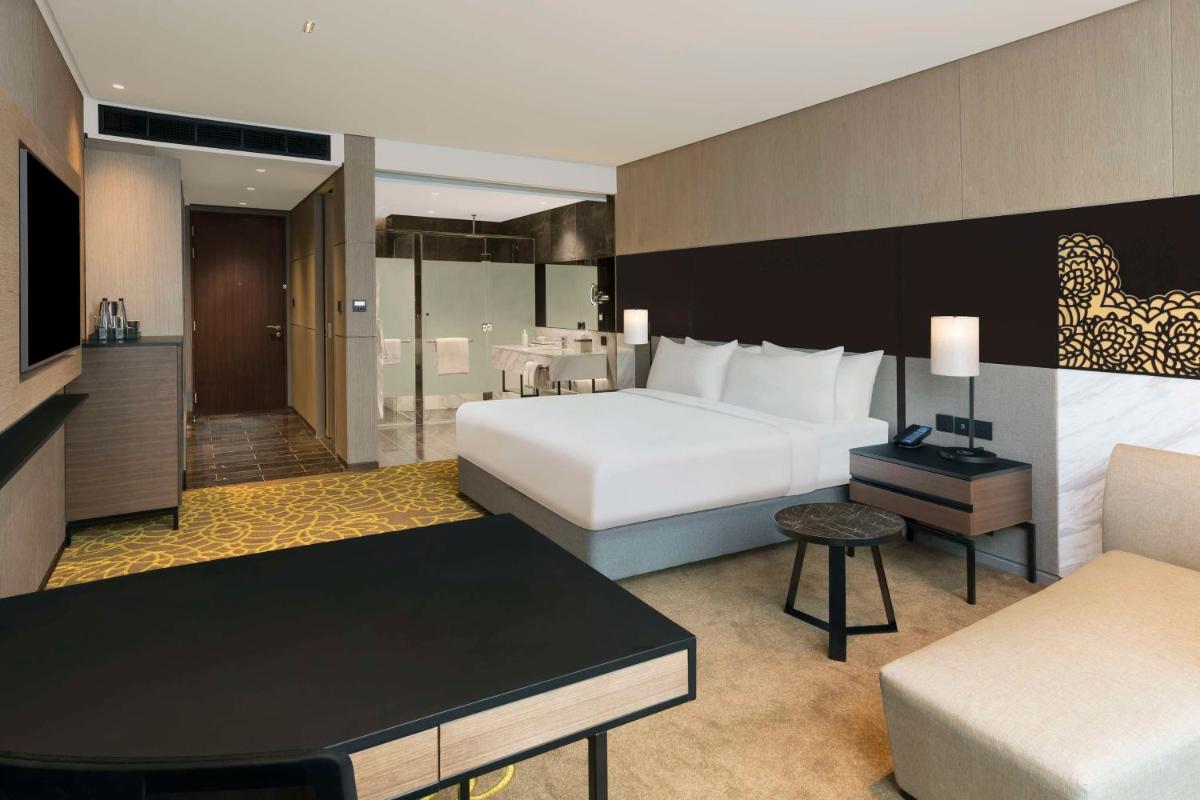 a hotel room with a bed and a living room at Hilton Bengaluru Embassy Manyata Business Park in Bengaluru