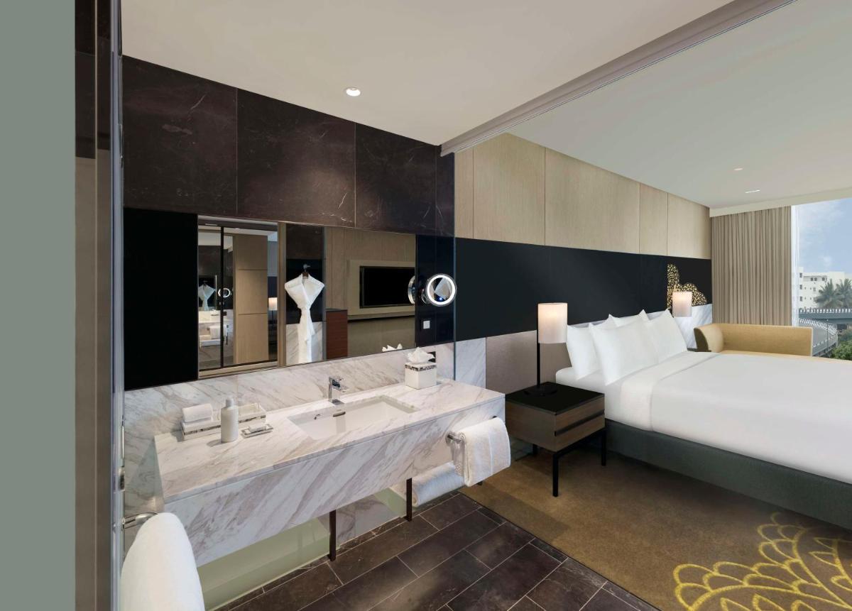 a hotel room with a bed and a sink at Hilton Bengaluru Embassy Manyata Business Park in Bengaluru