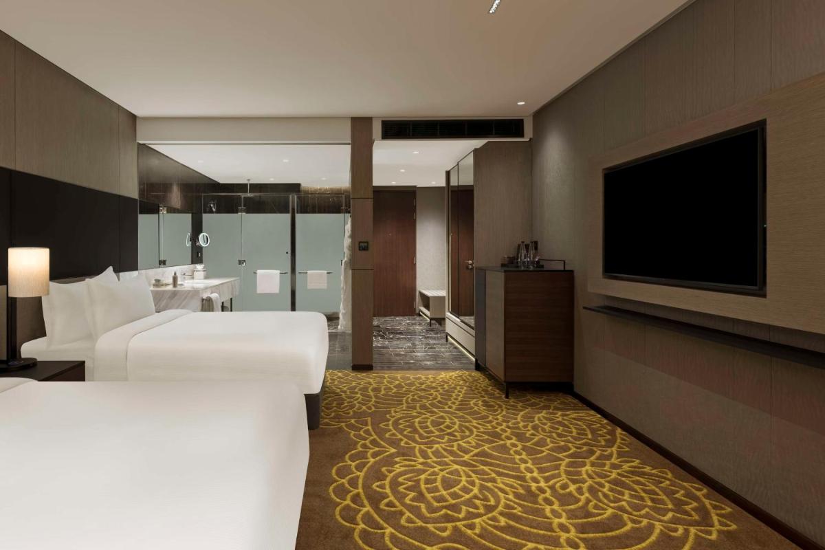 a hotel room with two beds and a flat screen tv at Hilton Bengaluru Embassy Manyata Business Park in Bengaluru