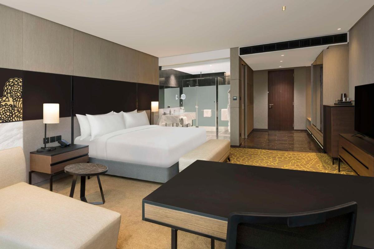 a large hotel room with a bed and a table at Hilton Bengaluru Embassy Manyata Business Park in Bengaluru