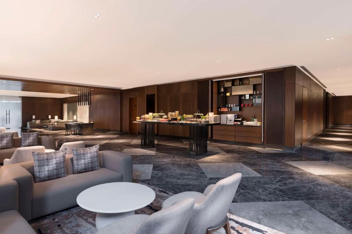 a lobby with couches and tables and a bar at Hilton Bengaluru Embassy Manyata Business Park in Bengaluru