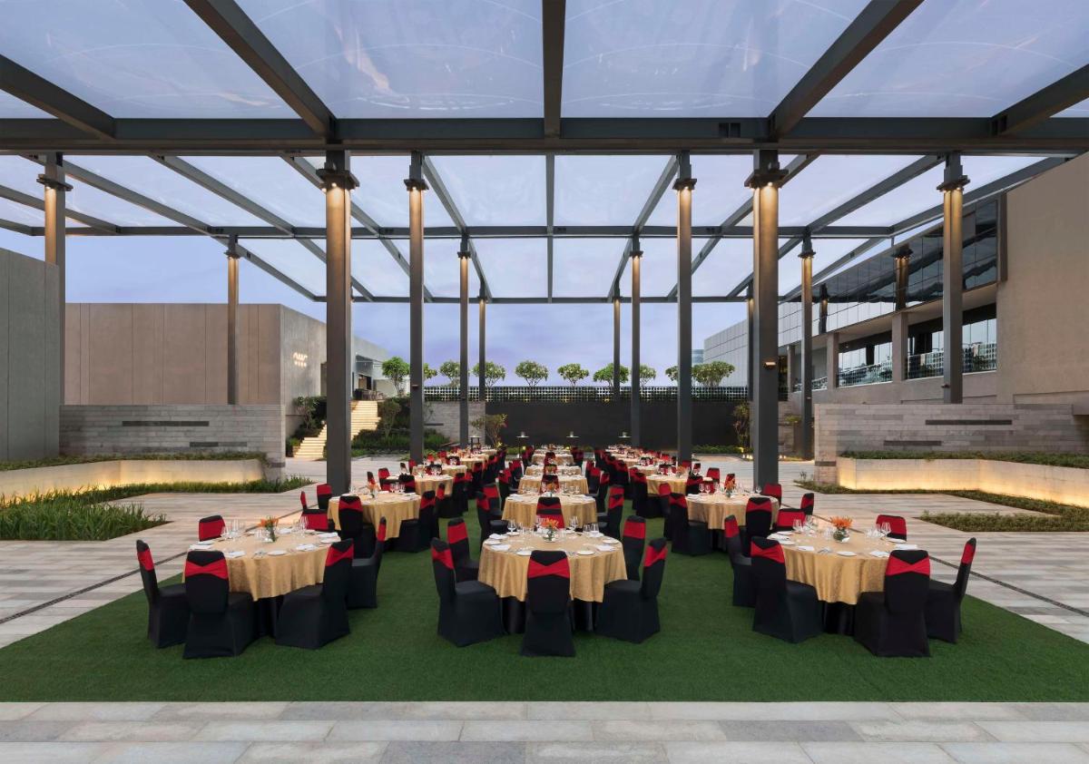 a rendering of a banquet hall with tables and chairs at Hilton Bengaluru Embassy Manyata Business Park in Bengaluru