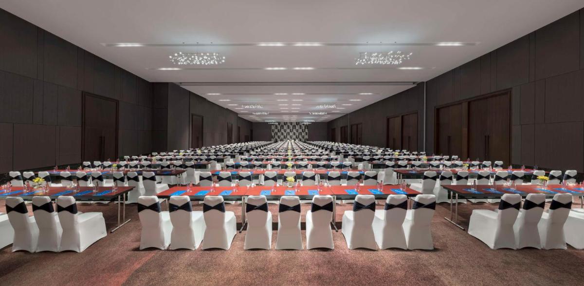 a large room with rows of tables and chairs at Hilton Bengaluru Embassy Manyata Business Park in Bengaluru
