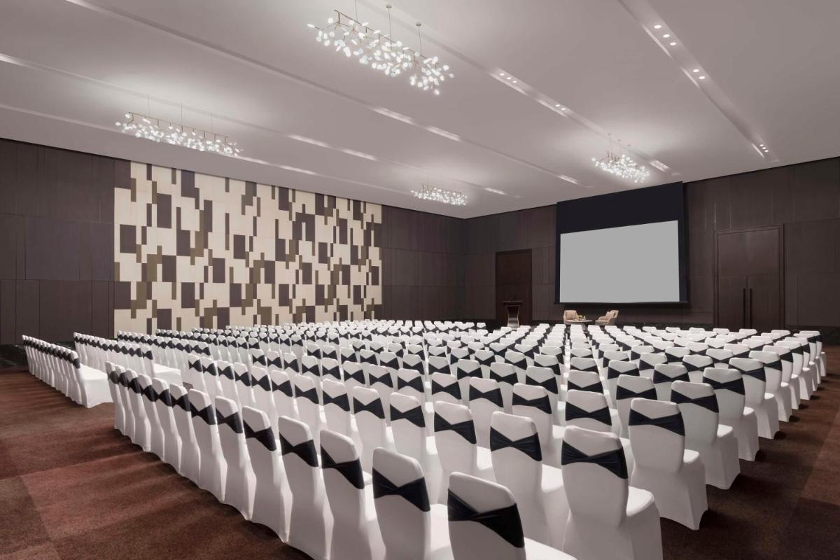 a conference room with chairs and a projection screen at Hilton Bengaluru Embassy Manyata Business Park in Bengaluru