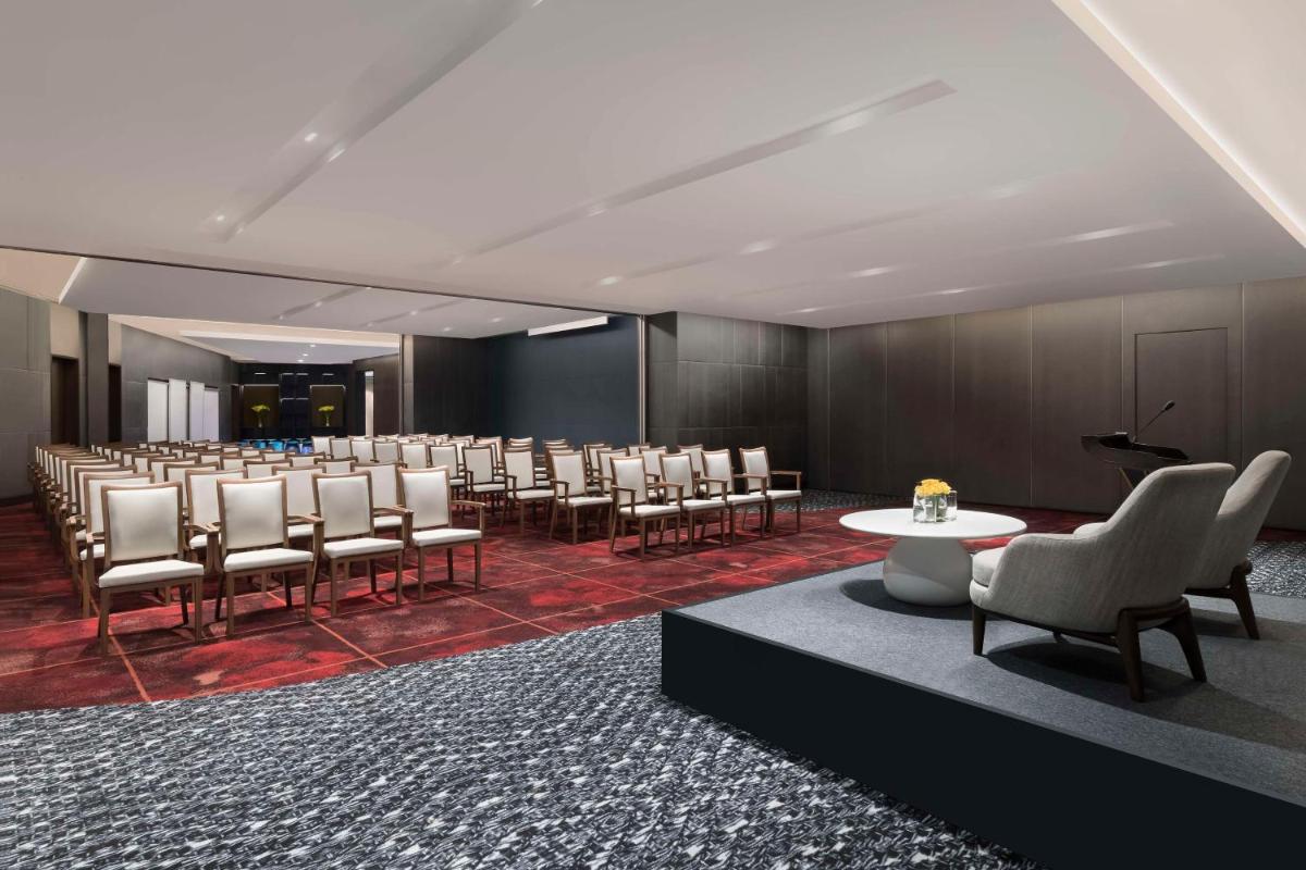 a conference room with a row of chairs and a podium at Hilton Bengaluru Embassy Manyata Business Park in Bengaluru