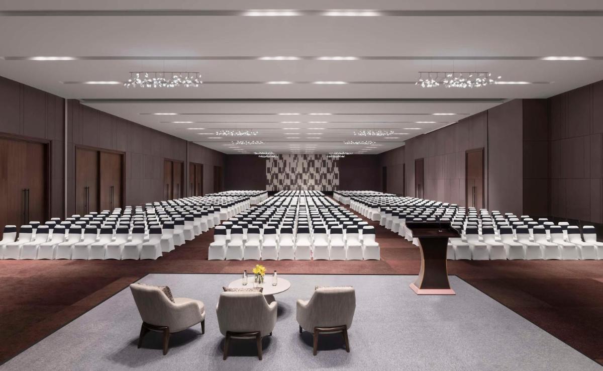 an empty room with rows of chairs and tables at Hilton Bengaluru Embassy Manyata Business Park in Bengaluru