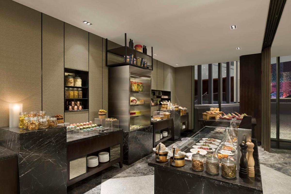 a bakery with a lot of food on display at Hilton Bengaluru Embassy Manyata Business Park in Bengaluru