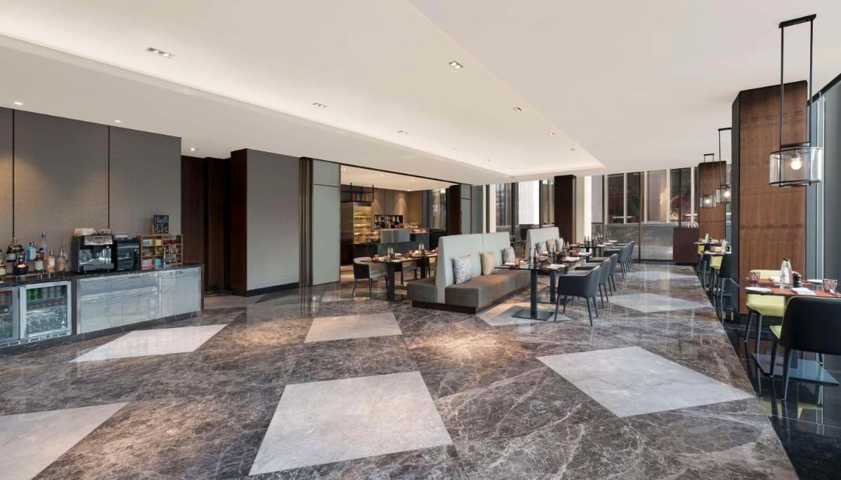 a lobby of a hotel with tables and chairs at Hilton Bengaluru Embassy Manyata Business Park in Bengaluru