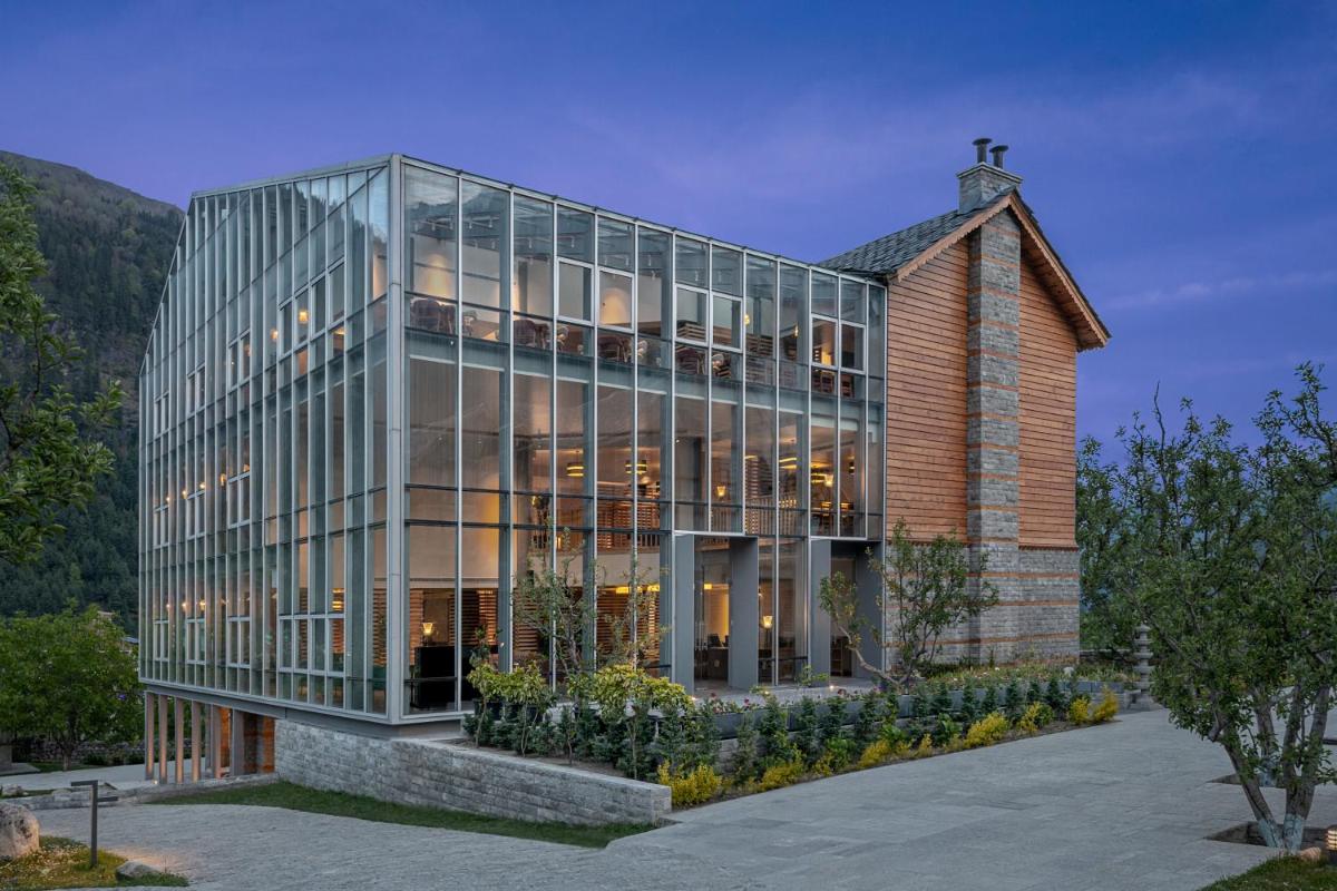 a building with glass windows on the side of it at Welcomhotel By ITC Hotels, Hamsa Manali in Manāli a building with glass windows on the side of it at Welcomhotel By ITC Hotels, Hamsa Manali in Manāli